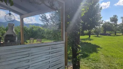 a view of a garden from a house with a window at Pool place in Petrovče