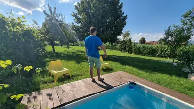 a man standing on a deck next to a pool at Pool place in Petrovče