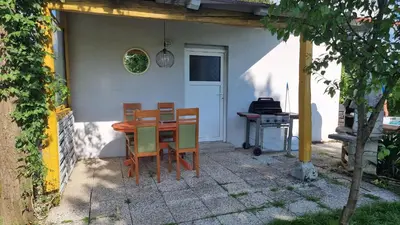 a table and chairs in front of a house at Pool place in Petrovče