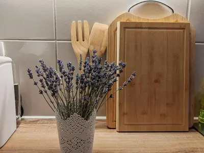 a vase with flowers in it next to a cutting board at Riverdance with mountain view, garden and private parking in Bled