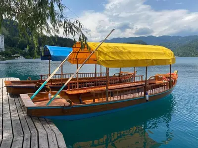 a wooden boat with a yellow cover on the water at Riverdance with mountain view, garden and private parking in Bled