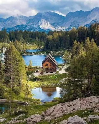 a house in the middle of a lake with mountains at Riverdance with mountain view, garden and private parking in Bled