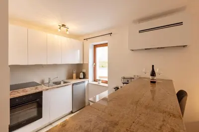a kitchen with white cabinets and a wooden counter top at Roland House with Pool & Winery in Stara Vas-Bizeljsko