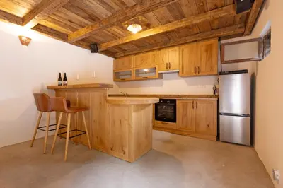 a kitchen with wooden cabinets and a stainless steel refrigerator at Roland House with Pool & Winery in Stara Vas-Bizeljsko