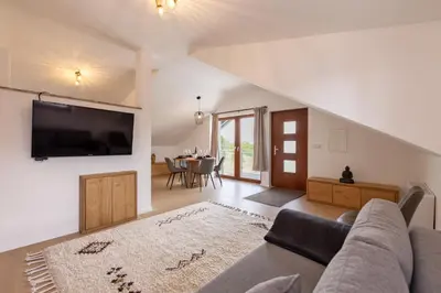 a living room with a couch and a tv on a wall at Roland House with Pool & Winery in Stara Vas-Bizeljsko