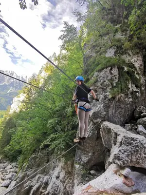 a woman walking on a zip line in the mountains at Apartment Studio MY RESIDENCE in the city center in Ljubljana