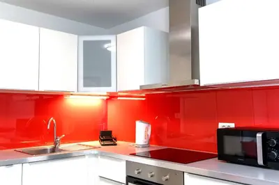 a red kitchen with a sink and a microwave at Apartment Studio MY RESIDENCE in the city center in Ljubljana