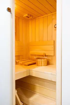 a sauna with wooden cabinets and a basket in it at Prosecco apartment in Bovec