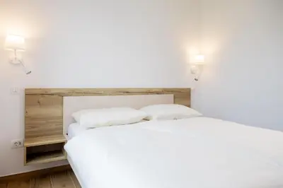 a bedroom with a white bed with two pillows at Prosecco apartment in Bovec