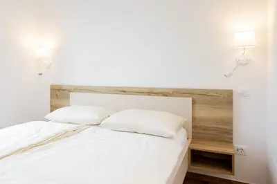 a bedroom with a white bed with two pillows at Prosecco apartment in Bovec