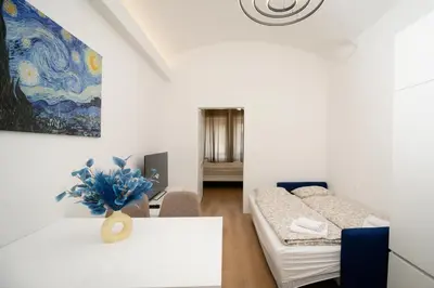a room with a bed and a table and a painting at MM NEW cozy modern apartment in Ljubljana