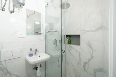 a white bathroom with a shower and a sink at MM NEW cozy modern apartment in Ljubljana