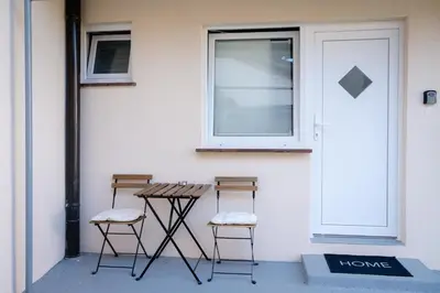 two chairs and a table in front of a door at MM NEW cozy modern apartment in Ljubljana