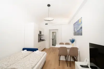 a bedroom with two beds and a table and chairs at MM NEW cozy modern apartment in Ljubljana