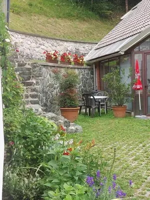 a garden with a table and chairs and flowers at Ferienwohnung Bohinj in Bohinjska Bistrica