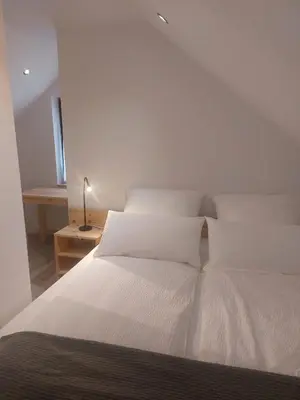 a white bed with white sheets and pillows at Ferienwohnung Bohinj in Bohinjska Bistrica