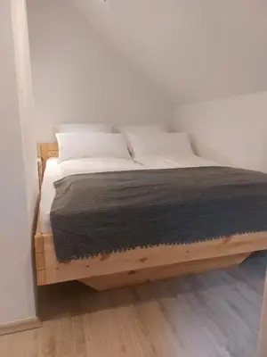 a bed with a wooden frame in a room at Ferienwohnung Bohinj in Bohinjska Bistrica