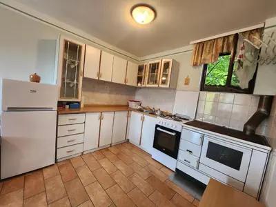 a kitchen with white cabinets and a white refrigerator at Hiša Heidi in Zavrč