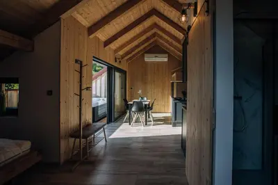 a room with a wooden ceiling and a dining room at Štajerska sivka - Jacuzzi & Savna in Maribor