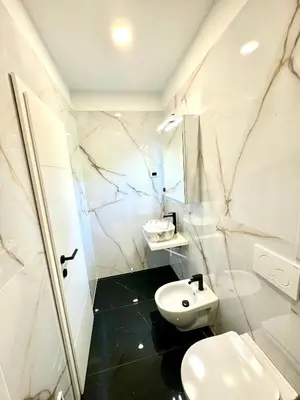 a white bathroom with a sink and a toilet at Apilandia Nanos in Vipava