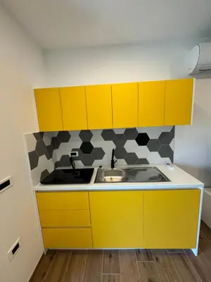a kitchen with yellow cabinets and a sink at Apilandia Nanos in Vipava