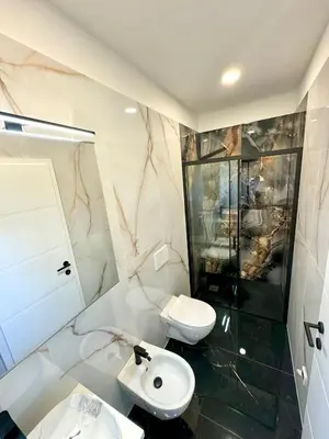 a white bathroom with a toilet and a sink at Apilandia Nanos in Vipava