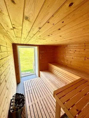 a wooden sauna with a bench and a window at Apilandia Nanos in Vipava