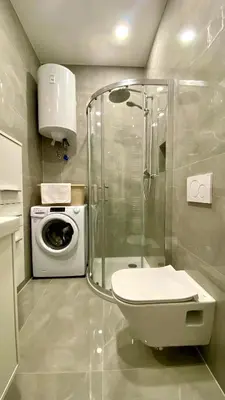 a bathroom with a toilet and a washing machine at Little Plaza Duplex in Ljubljana