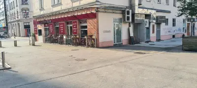 an empty street with tables and chairs outside a building at Little Plaza Duplex in Ljubljana