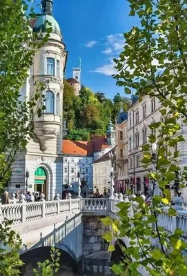 a bridge over a river in a city with buildings at Little Plaza Duplex in Ljubljana
