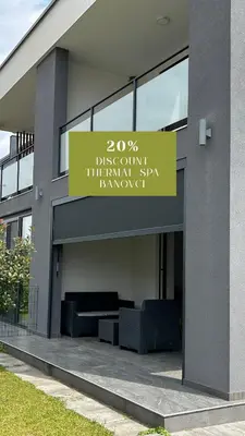 a building with a sign on the side of it at AURORA Apartment Banovci in Banovci