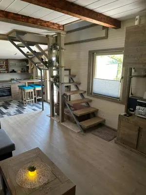 a living room with a staircase in a tiny house at Močvirski Tulipan in Ljubljana