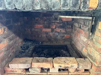 a brick oven with a grill in a brick wall at Močvirski Tulipan in Ljubljana