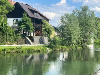 a house with a river in front of it at Riverside House Krka in Zagradec