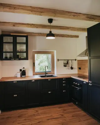a kitchen with black cabinets and a window at Riverside House Krka in Zagradec