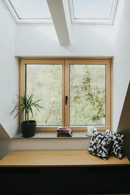 a window seat with two pillows and a plant at Riverside House Krka in Zagradec