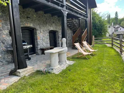 a stone building with a bench and some chairs at Riverside House Krka in Zagradec