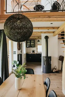 a dining room with a table and a wood stove at Riverside House Krka in Zagradec