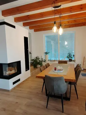 a dining room with a table and a fireplace at Hiška pri brajdah in Videm pri Ptuju