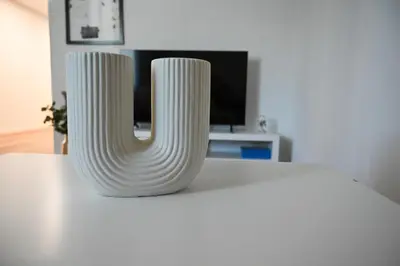 two white vases sitting on top of a table at Apartma Cave Bliss Maribor in Maribor