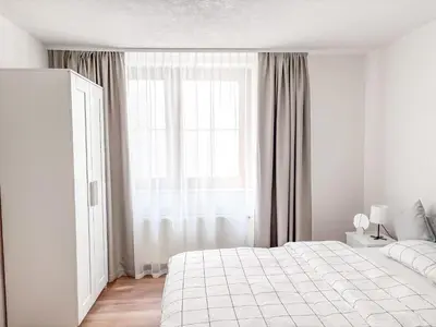 a bedroom with a white bed and a window at Apartma Cave Bliss Maribor in Maribor