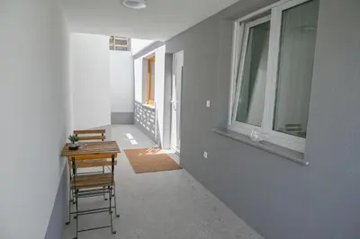 a hallway with two chairs and a table and two windows at Apartma Cave Bliss Maribor in Maribor