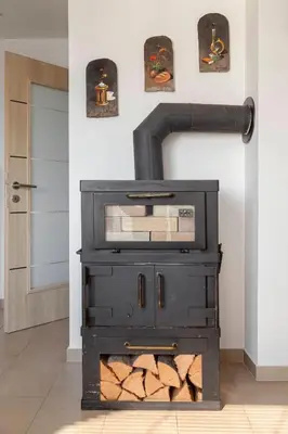 a black stove in a room with a wall at Hiša Oder in Woditz