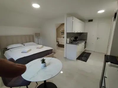 a bedroom with a bed and a table and a kitchen at Hiša Oder in Woditz