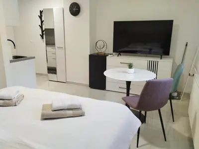 a living room with a tv and a table and chairs at Hiša Oder in Woditz
