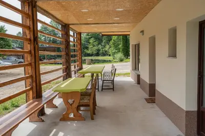 a covered porch with tables and chairs and windows at Ribnik Stari trg in Lesično