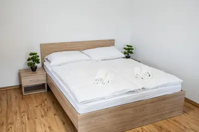 a bedroom with a bed with white sheets and slippers at Ribnik Stari trg in Lesično