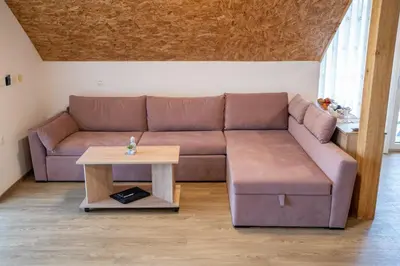 a living room with a brown couch and a table at Ribnik Stari trg in Lesično