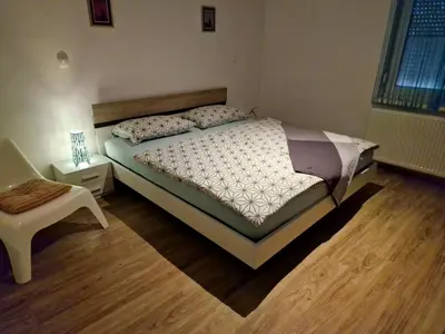 a bedroom with a bed and a chair in it at Apartment Lublana in Ljubljana