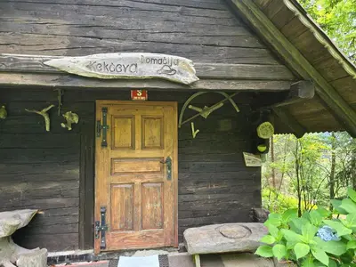 an entrance to a wooden house with a door at Lisičja bajta in Stahovica